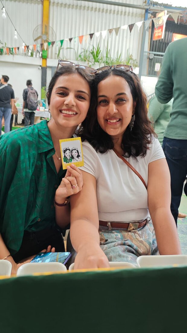 Two friends showing off their doodle card at an event